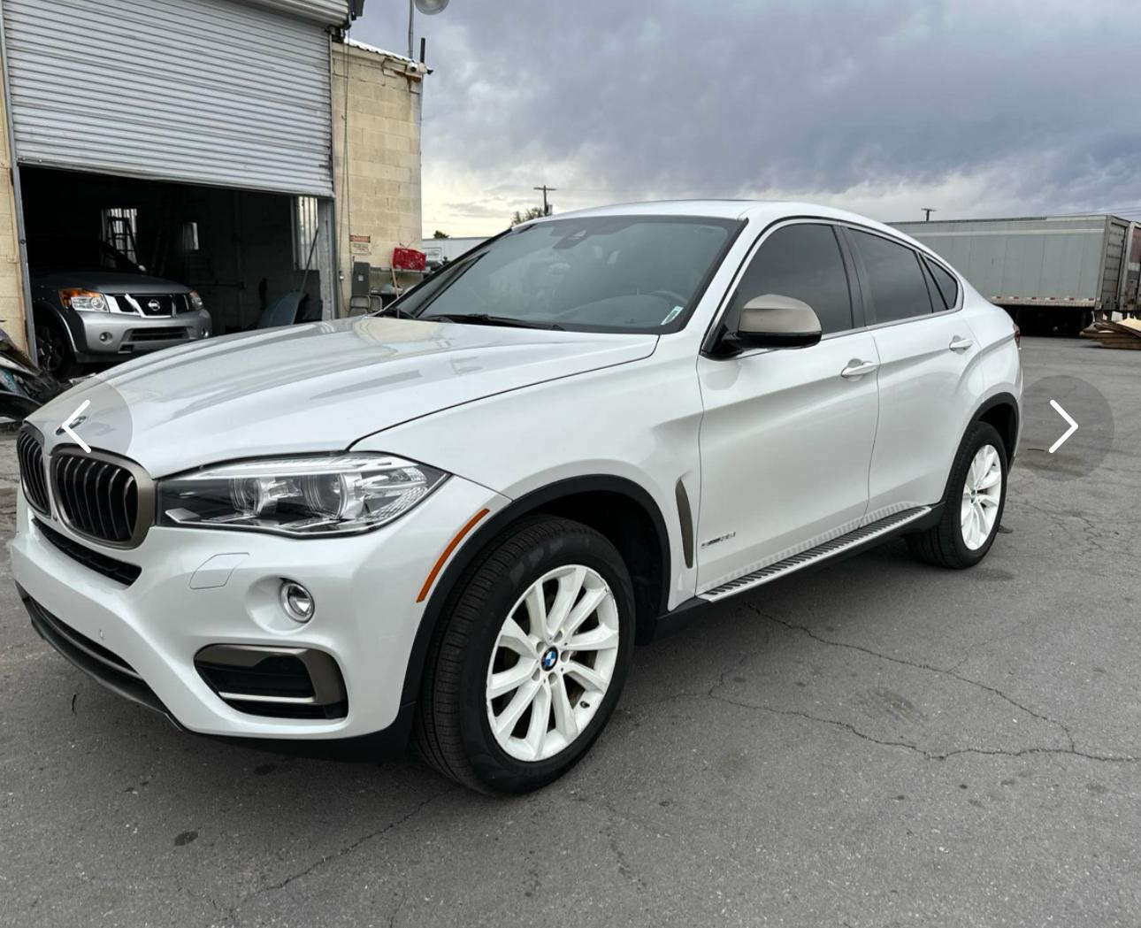 White BMW X6 parked outside the shop