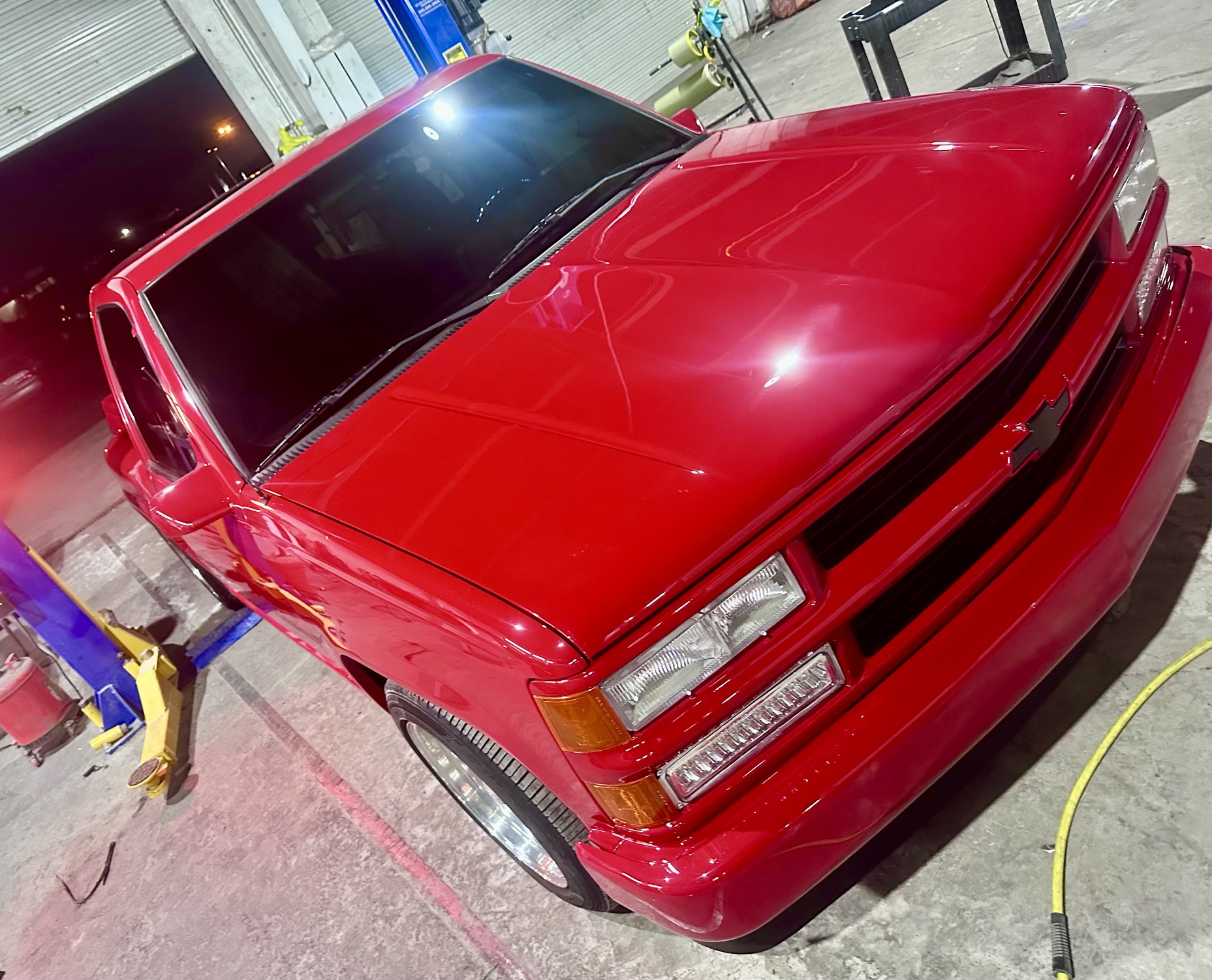 Freshly painted red Chevrolet OBS truck in the shop