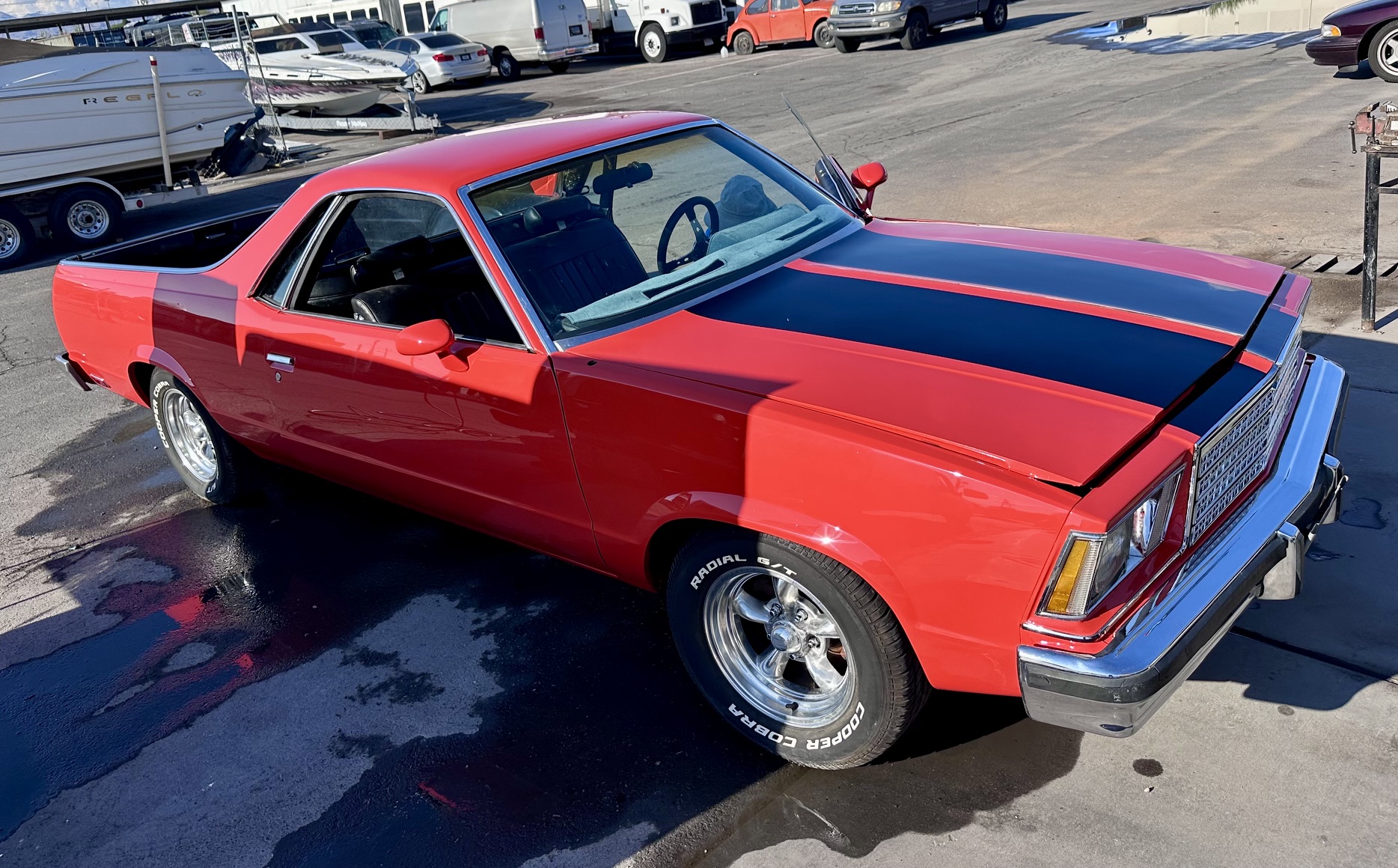 Red Chevrolet El Camino with black racing stripes