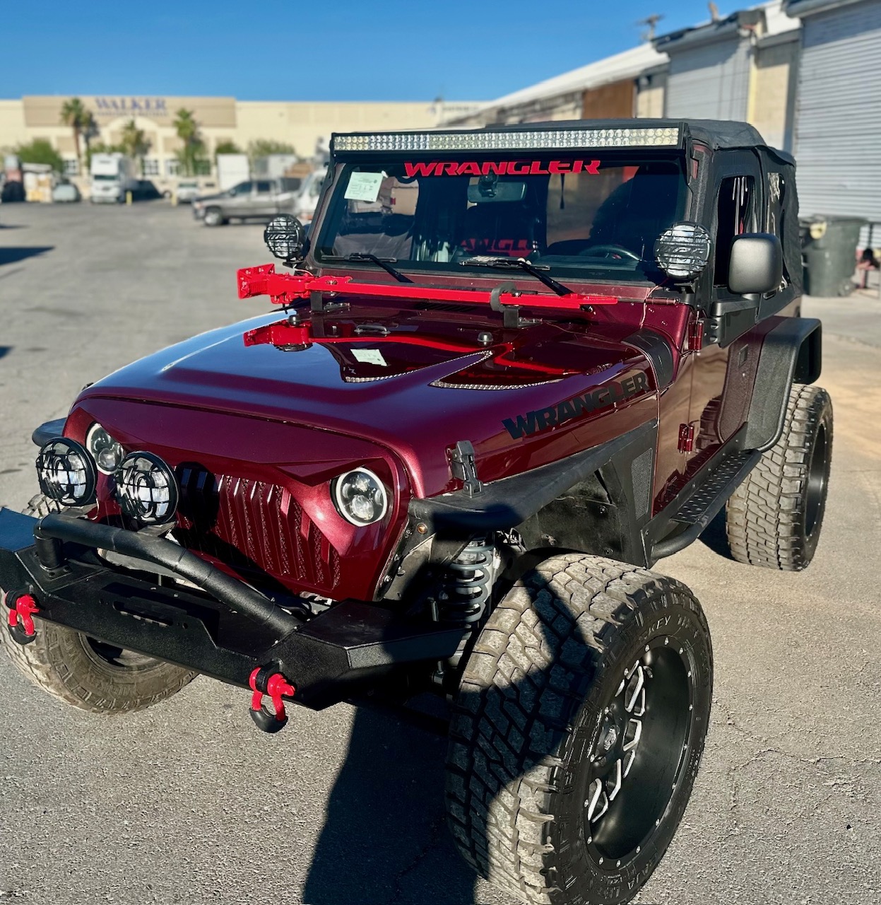 Burgundy Jeep Wrangler with light bar and custom bumper